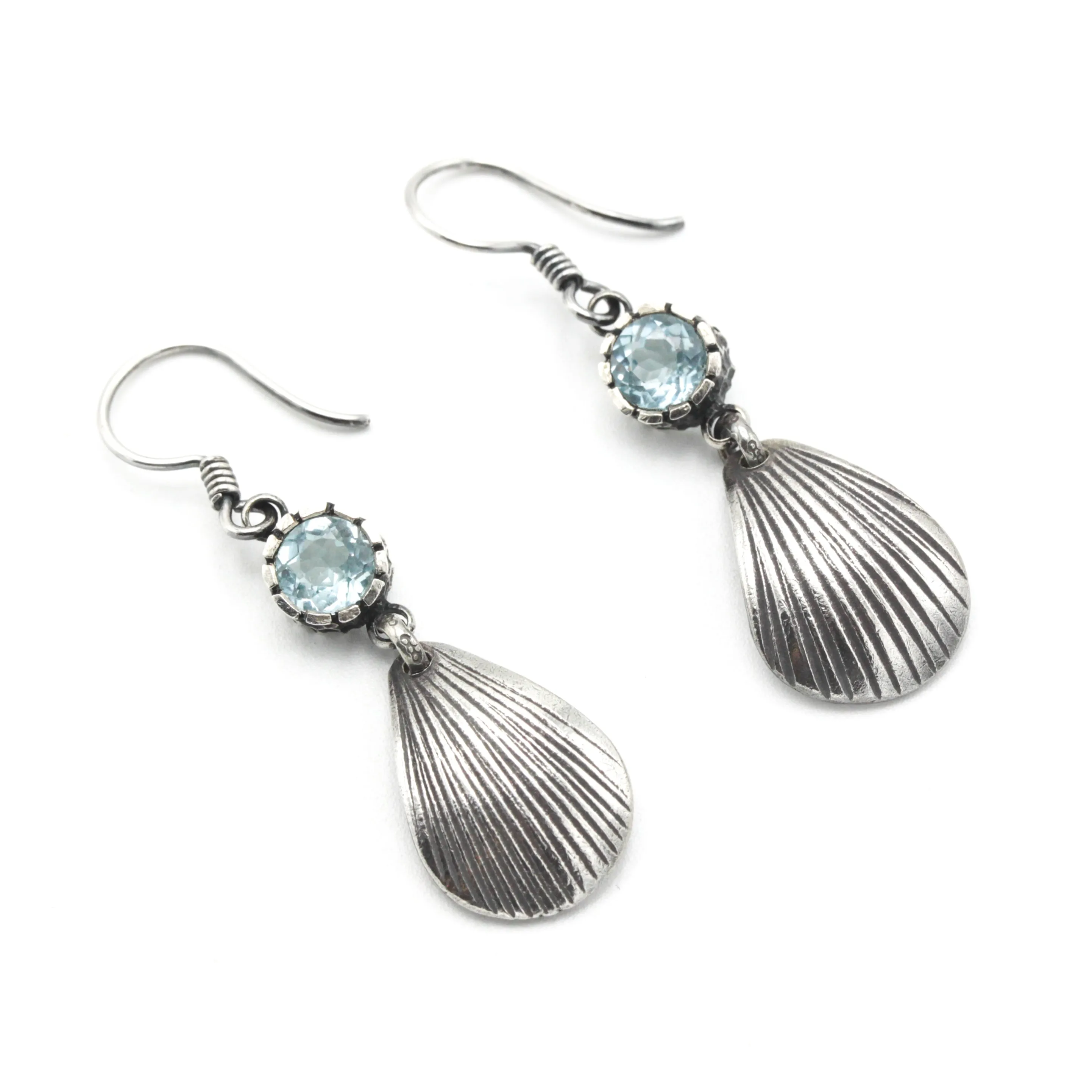 Blue topaz earrings in silver bezel setting with sterling silver shell shape on silver hooks style