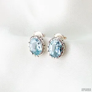 Sterling Silver Oval Faceted Blue Topaz Stud Earrings with Intricate Carved Bezels
